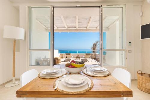 een eetkamer met een tafel en uitzicht op de oceaan bij Palma Residence Salento in San Foca