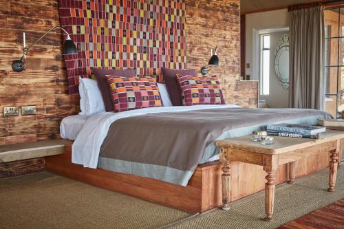 a bedroom with a large bed and a table at Loisaba Lodo Springs in Tura