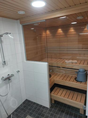 a sauna with wooden shelves in a bathroom at Apartment Kauppatie, neljälle hengelle in Laihia