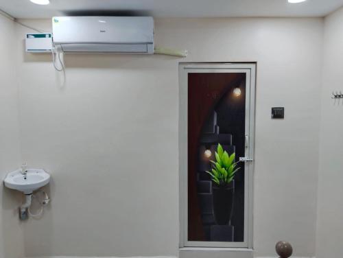 a bathroom with a door with a plant in it at VIJAY BALAJI MAHAL A/C in Tiruvannāmalai