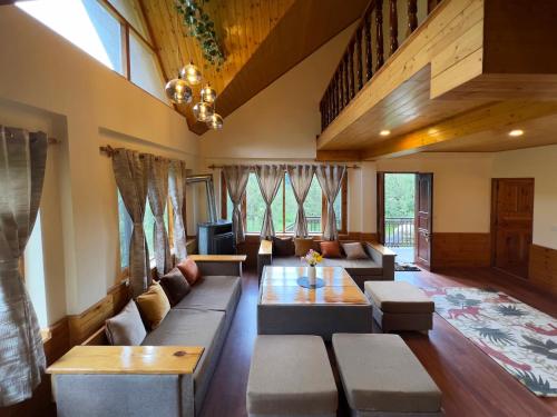 a living room with a couch and a table at Molly's Cottage in Manāli