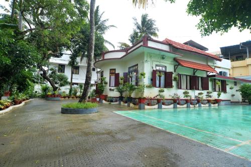 a resort with a swimming pool in front of a building at Remasailam Homestay - Thiruvananthapuram , Calm & Blend with Nature in Trivandrum