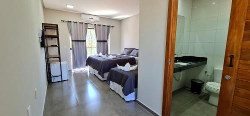 a bedroom with two beds and a bathroom with a toilet at Euro Flat Hotel in Parnaíba