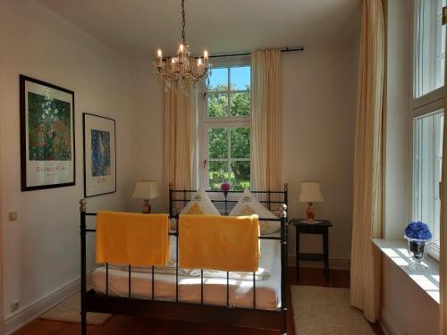 1 Schlafzimmer mit einem Bett mit 2 Stühlen und einem Fenster in der Unterkunft Kamin-Stuuv in Stubbendorf