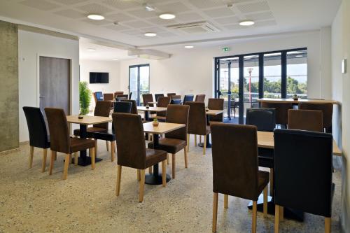 a conference room with tables and chairs and windows at Résidence Easy Lodge in Ajaccio
