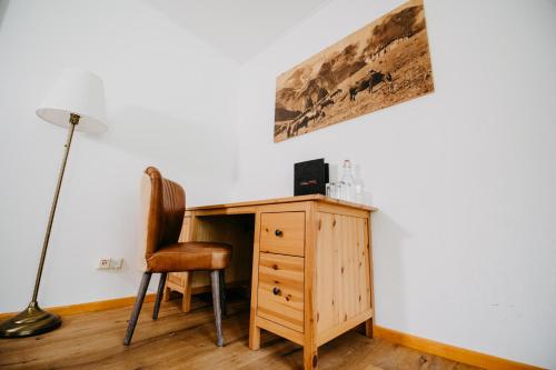 a wooden desk with a chair and a lamp at Vitalhotel Gosau in Gosau