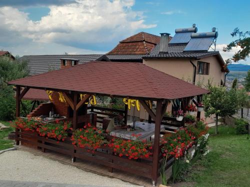 a gazebo with flowers in front of a house at Casa Alex in Topliţa