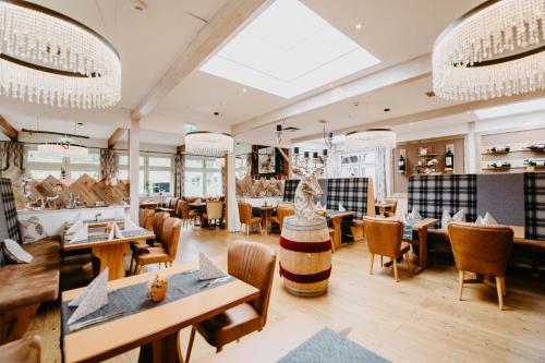 a restaurant with wooden tables and chairs and a large window at Vitalhotel Gosau in Gosau