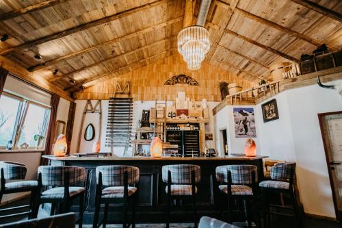 a bar in a restaurant with wooden ceilings and chairs at Vitalhotel Gosau in Gosau
