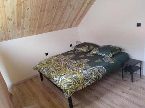 a bedroom with a bed with a green comforter at Domek u Antosia in Mechelinki