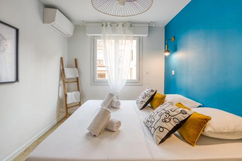 une chambre avec un grand lit avec un mur bleu dans l'établissement Appartement Wilsonia - Welkeys, à Antibes