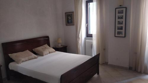 1 dormitorio con 1 cama blanca grande y ventana en Agriturismo Lo Scoiattolo, en Ronciglione