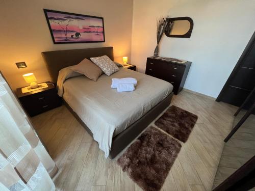 een slaapkamer met een bed met 2 nachtkastjes en 2 lampen bij La Regina in Vigevano