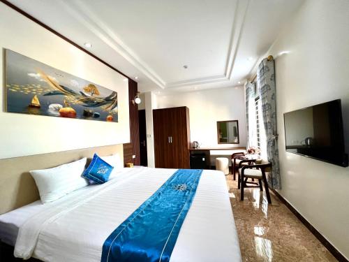 ein Hotelzimmer mit einem großen Bett und einem TV in der Unterkunft Khách sạn Ngọc Hà in Lào Cai