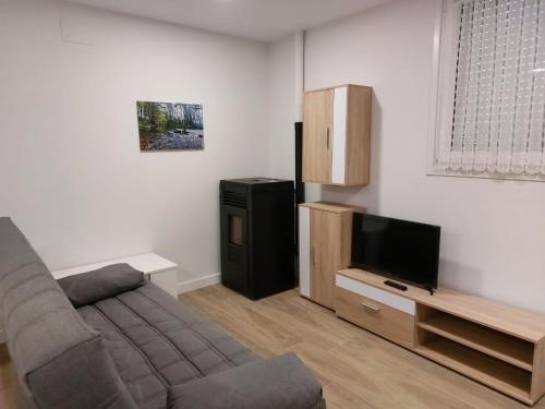 a living room with a couch and a flat screen tv at Casa Korrontxas & Ega Txokoa in Murieta