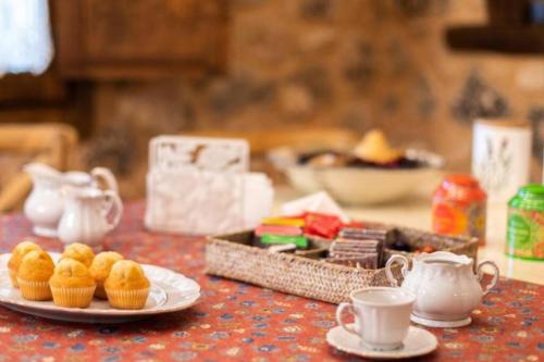 a table with a plate of muffins and cups of tea at Casa Rural LA LAVANDA Lugar de ensueño en la Alcarria in El Olivar