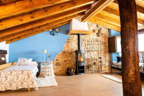 a bedroom with a bed and a wood stove at Casa Rural LA LAVANDA Lugar de ensueño en la Alcarria in El Olivar