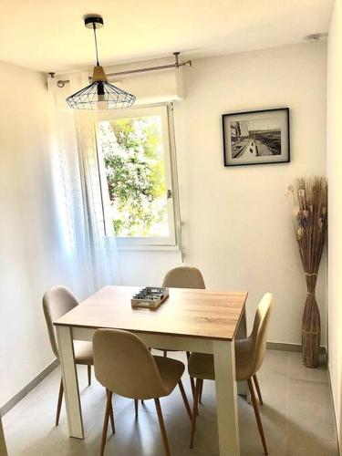 une table à manger avec des chaises et une fenêtre dans l'établissement Un coin de paradis 2 ou 4 personnes refait à neuf, à Sainte-Maxime