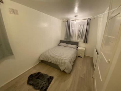 a small bedroom with a bed and a window at 2 bedroom flat with balcony London in London