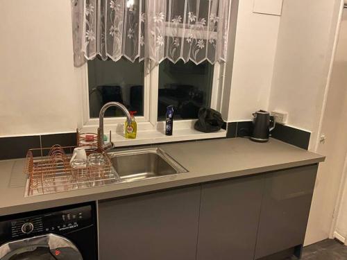 a kitchen counter with a sink and a dishwasher at 2 bedroom flat with balcony London in London