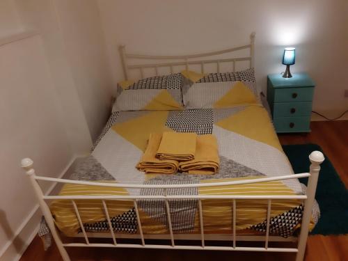 a bedroom with a bed with yellow pillows at Ground Floor Barmouth Centre Apartment With Garden in Barmouth