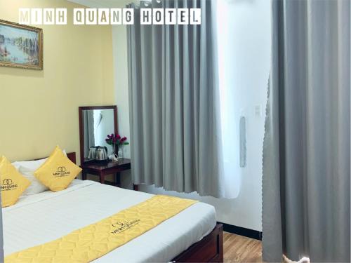 - une chambre avec un lit, un miroir et des rideaux dans l'établissement Khách sạn Minh Quang, à Phan Rang