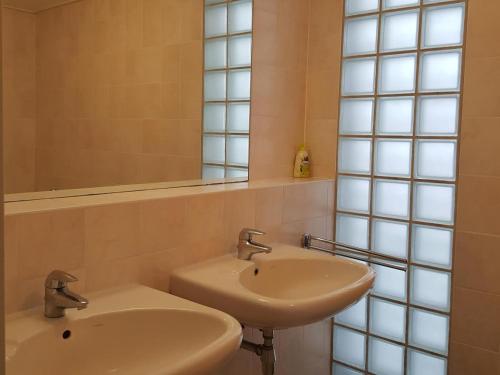 Un baño con dos lavabos y un espejo. en Mees, en Hollum