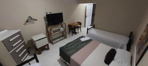 a bedroom with a bed and a flat screen tv at Pousada Zambeze in Praia Grande