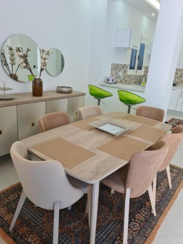 uma mesa de madeira e cadeiras num quarto em Villa Bleue plage Sonia em Zarzis