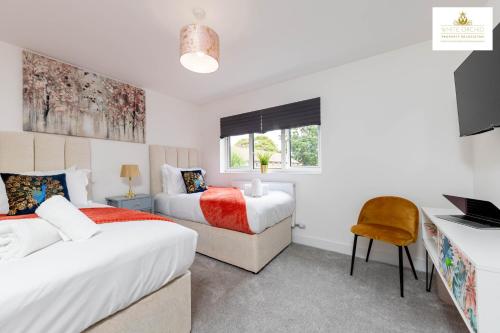 1 Schlafzimmer mit 2 Betten und einem Schreibtisch mit einem Laptop in der Unterkunft 3Bed 2Bath House Contractors Accommodation free Parking WiFi Stevenage Hertfordshire Self Catering Sleeps 6 Guests By White Orchid Property Relocation in Stevenage