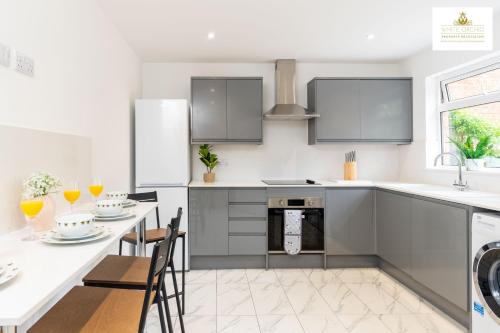a kitchen with a table and chairs and a sink at Contractors 3 Bed 2Bath House Free Off Street Parking for 2 Cars WiFi Stevenage Self Catering Sleeps 5 Guests By White Orchid Property Relocation in Stevenage