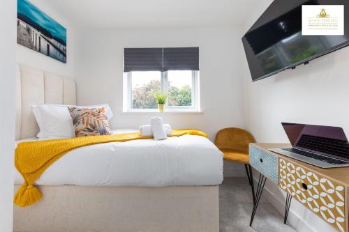 a bedroom with a bed and a desk with a laptop at Contractors 3 Bed 2Bath House Free Off Street Parking for 2 Cars WiFi Stevenage Self Catering Sleeps 5 Guests By White Orchid Property Relocation in Stevenage