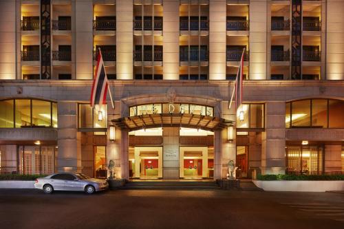 une voiture garée devant un bâtiment dans l'établissement The Davis Bangkok, à Bangkok