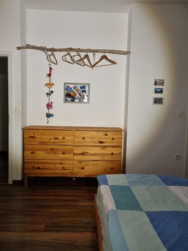 a bedroom with a wooden dresser and a bed at BikeSki family hotel, b&b, apartaments, rooms in Mežica