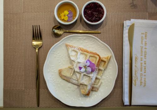 a plate with two pieces of toast with a flower on it at Blumen Hotel Boutique in Canela
