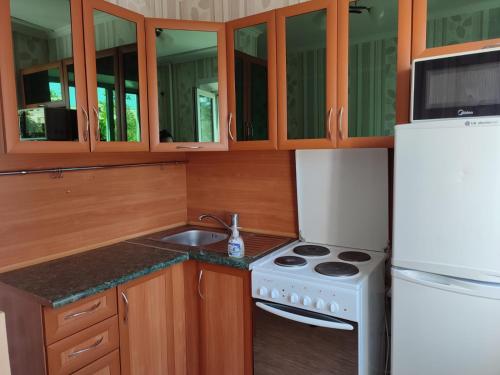 a kitchen with a white stove and a refrigerator at Стандарт апартаменты ул.Урицкого 74 in Pavlodar