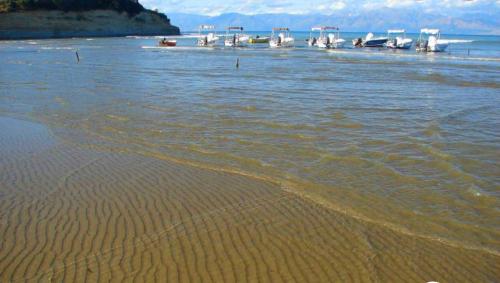 a beach with a group of boats in the water at Perland Vacation in Sidari