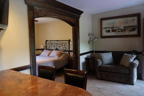 a bedroom with a bed and a couch and a mirror at Chalet Inn & Suites in Centerport