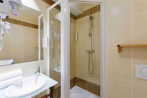 a bathroom with a shower and a sink at Kyriad Crepy En Valois in Crépy-en-Valois