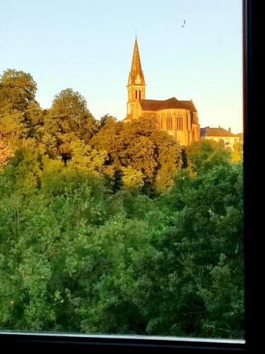 a church sitting on top of a hill with trees at VALLÉE 1900 in Torfou