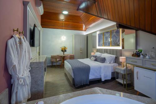 Blumen Hotel Boutique في كانيلا: غرفة نوم كبيرة بها سرير وحمام