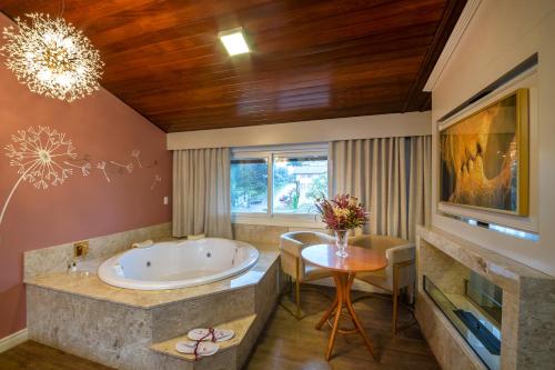 卡內拉的住宿－Blumen Hotel Boutique，一间带大浴缸、桌子和椅子的浴室
