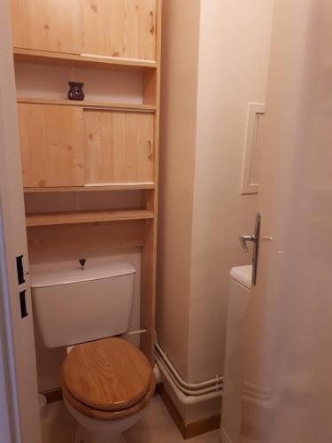 Elle comprend une petite salle de bains pourvue de toilettes et d'un siège en bois. dans l'établissement Terrasses de la Foux Coquet studio 80m Labrau 4 couchages, à La Foux