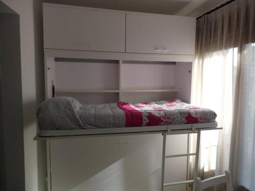 a bed on a shelf in a room with a window at Cal Magí in Sant Martí de Maldá