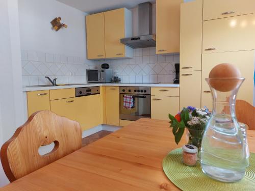 eine Küche mit einem Holztisch mit einer Vase darauf in der Unterkunft Grimmingapartment Maier in Stainach
