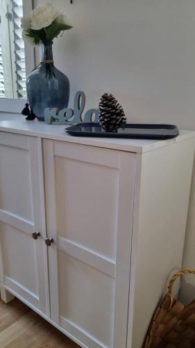 a white cabinet with a vase on top of it at PLACE 4 U Studio Center in Zadar