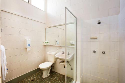 La salle de bains est pourvue de toilettes, d'un lavabo et d'une douche. dans l'établissement Sunnybank Hotel Brisbane, à Brisbane