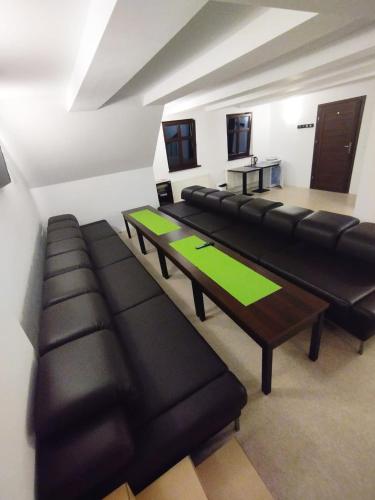 a room with black leather couches and a table at Koralowa Ścieżka in Jelenia Góra-Jagniątków