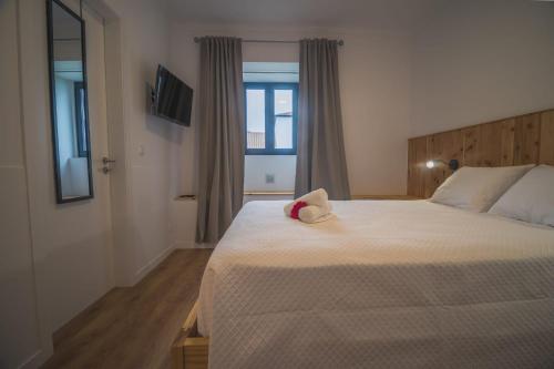 a bedroom with a bed with a stuffed animal on it at Vila Rosario in Ponta Delgada