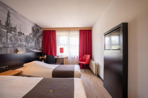 a bedroom with a white bed and white walls at Bastion Hotel Groningen in Groningen